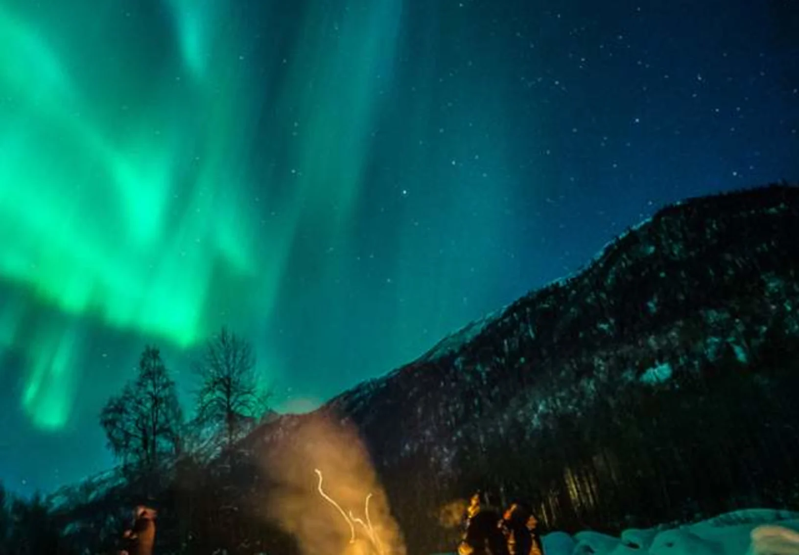 The Northern Lights over a group of campers in Alaska